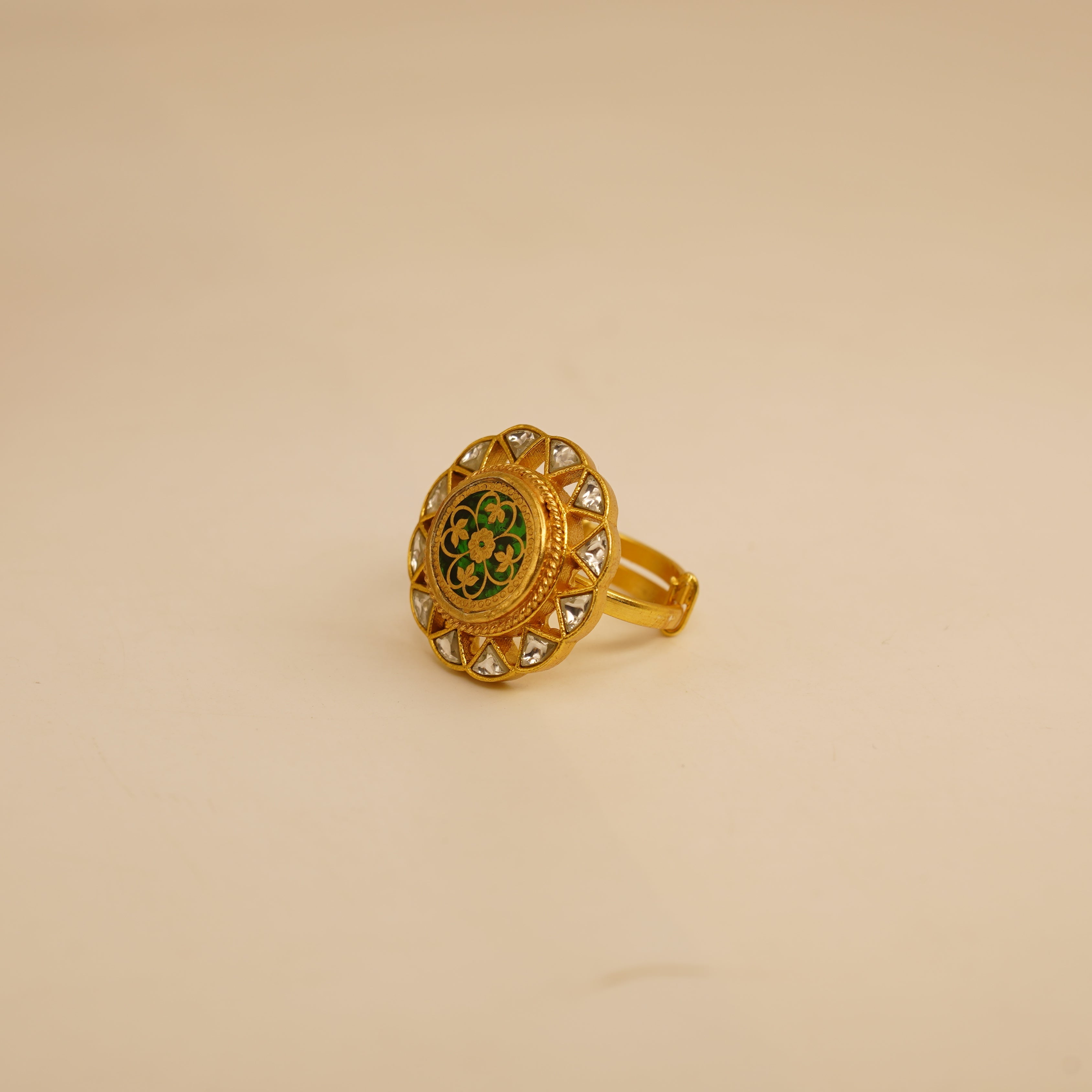 Gold ring with decorative design on a beige background