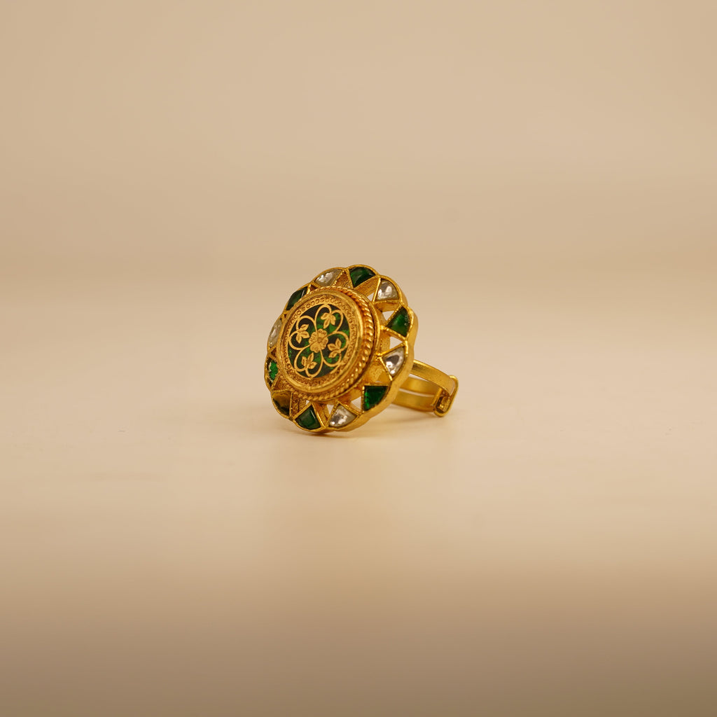 Gold ring with green gemstones on a beige background